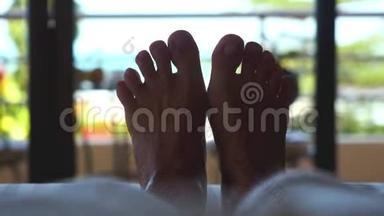 女人躺在旅馆的床上。 靠近挥动的双脚与热带海景。 3840x2160